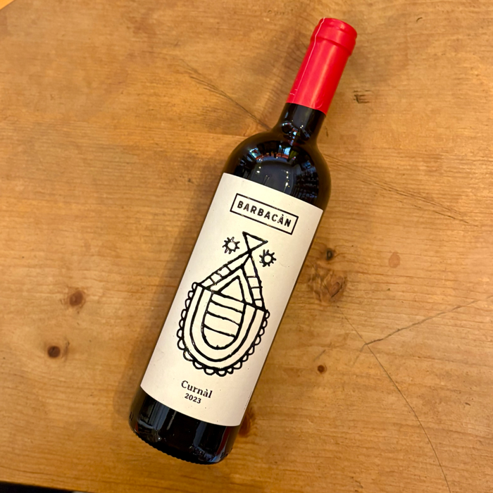 Wine bottle with red foil cap and cream label featuring black crest and text
