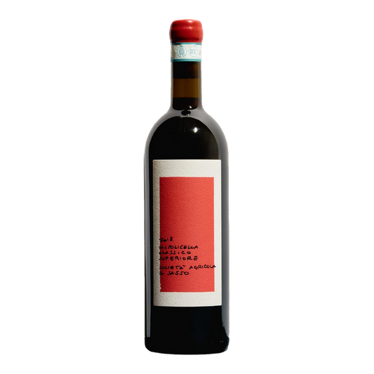 Red wine bottle with red cap and white label on dark glass, red label panel