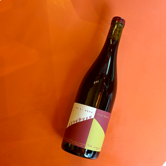 Angled red wine bottle with red foil cap and label in red and yellow panels